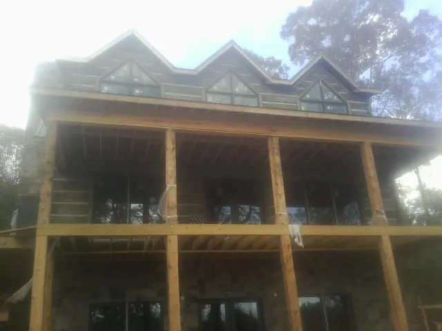 Dormers and porch framing on a large log home under construction — Roof Coating work by our crew in South Saint Paul