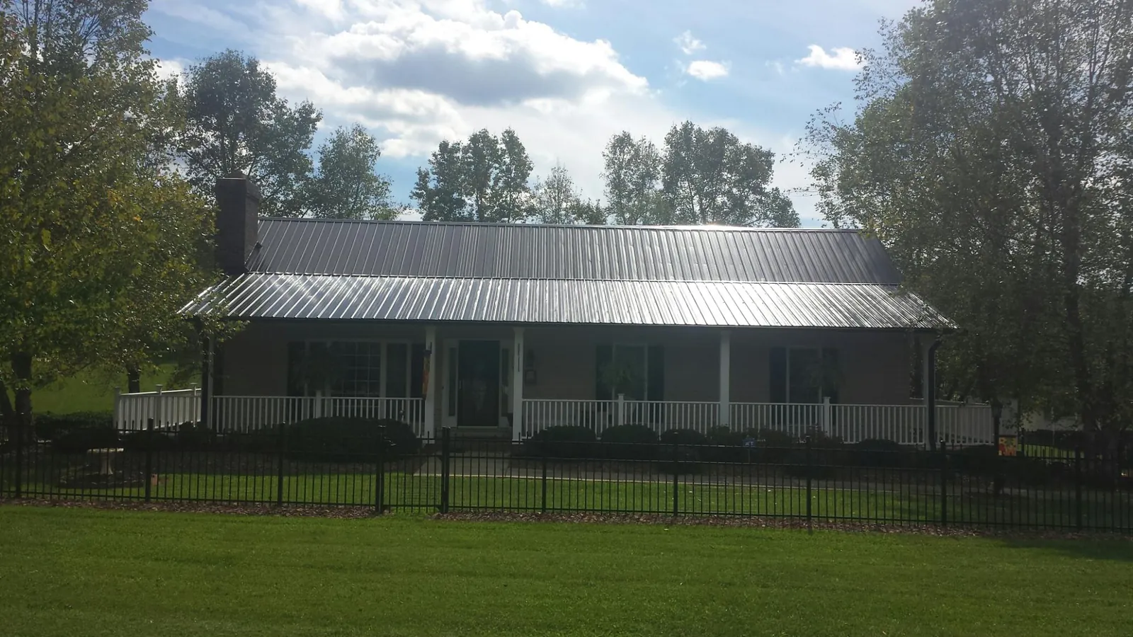 Gray metal roof on a brick ranch with a full width front porch — Gutter Guard Installation work by our crew in South Saint Paul